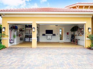 Spacious, clean three-car garage in Casselberry, FL, featuring custom wall storage, mounted bikes, a workbench, and neatly organized shelving.