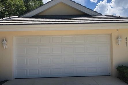 Exterior view of a white double garage door, fully operational after spring replacement, at a Fern Park, FL residence.