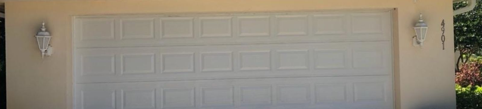 Exterior view of a white double garage door, fully operational after spring replacement, at a Fern Park, FL residence.
