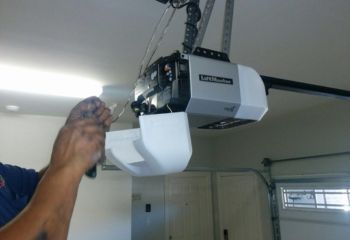 Technician repairing a LiftMaster myQ garage door opener by replacing the logic board inside a residential garage in Altamonte Springs, FL.
