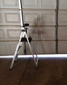 Close-up of worn torsion springs and a step ladder beneath a partially open garage door in Winter Springs, FL.
