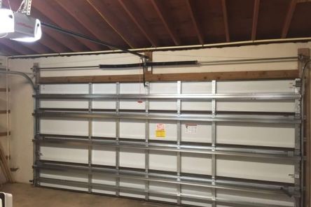 Interior view of the new garage door in Longwood, showing the insulated steel construction, horizontal supports, and a LiftMaster electric opener.
