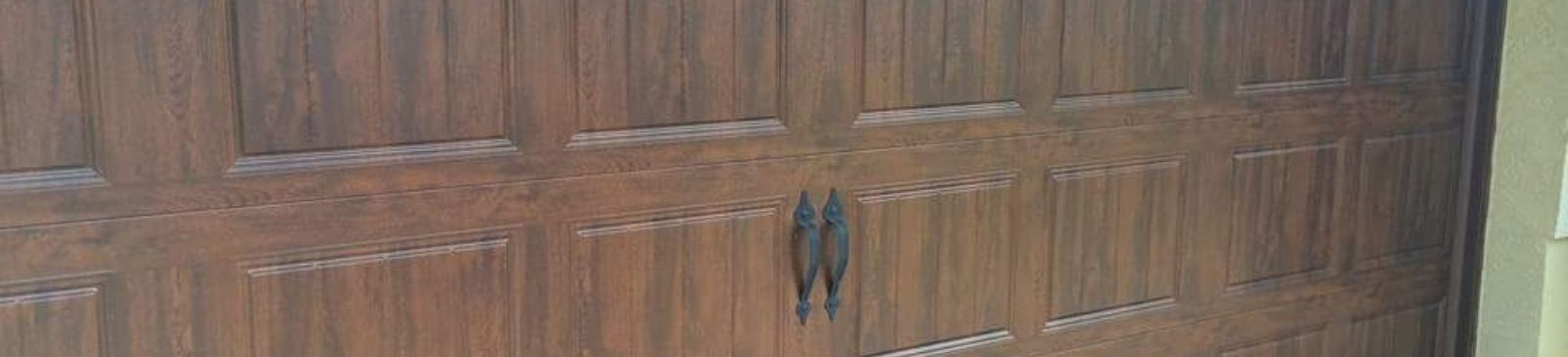 Angled exterior shot of the wood-grain garage door under an arched entryway, highlighting the realistic finish and upgraded hardware in Longwood, FL.
